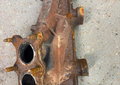 Heavily corroded exhaust manifold before blast cleaning and plasma coating
